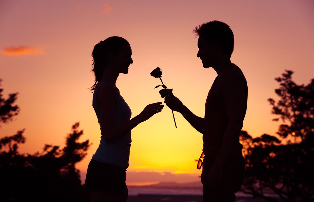 رجل يعطي إمرأة وردة حب