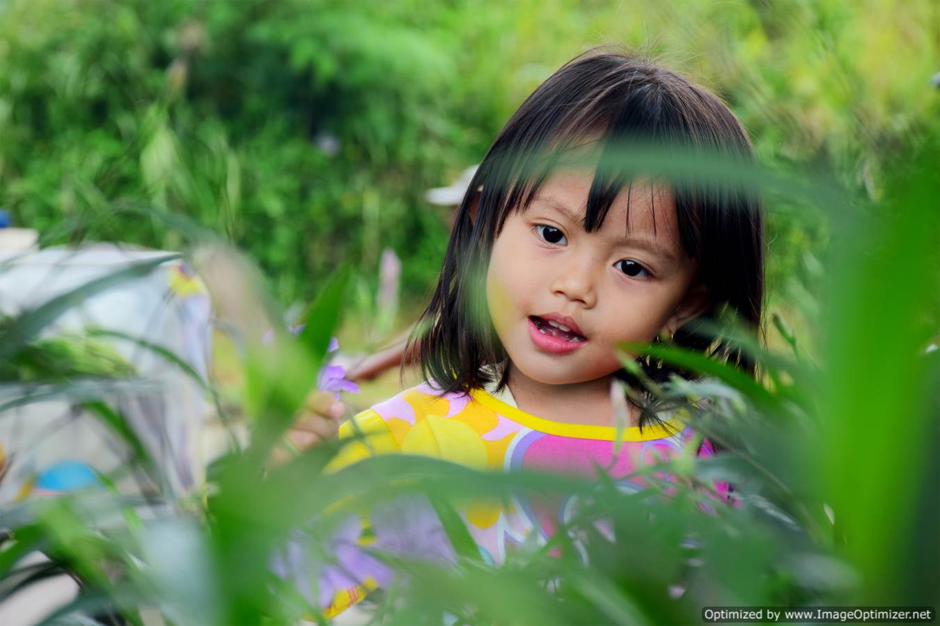 طفلة صغيرة شعرها اسود جميل وسط الخضرة والاشجار