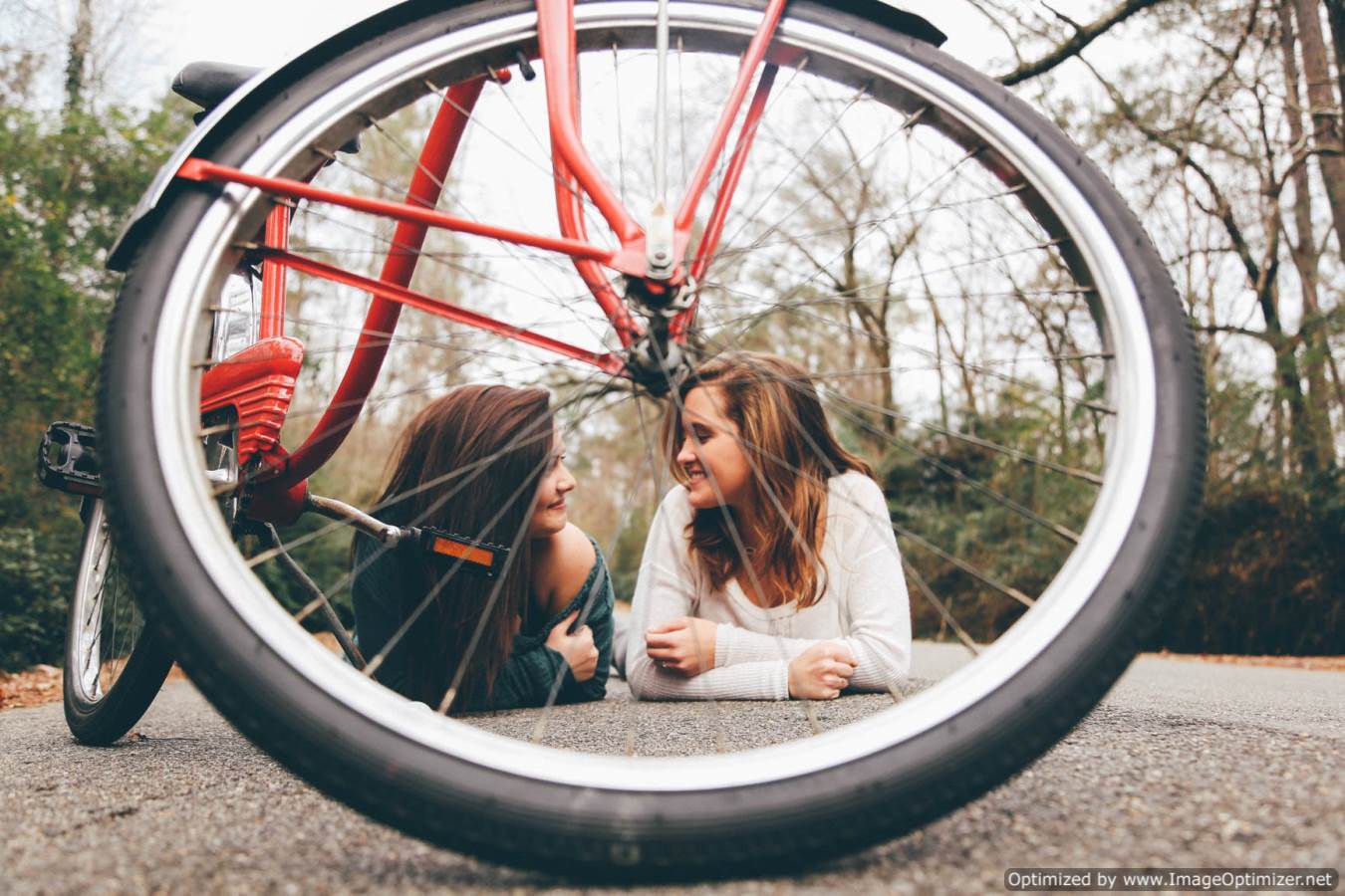 فتاتين جميلتين امامهم دراجة ويتصورون خلفها