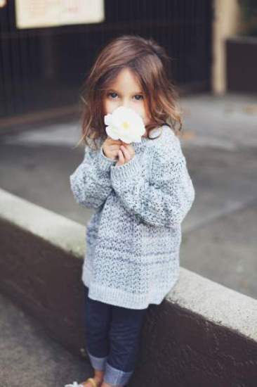 صور طفلة تحمل وردة بيضاء شكلها قمر