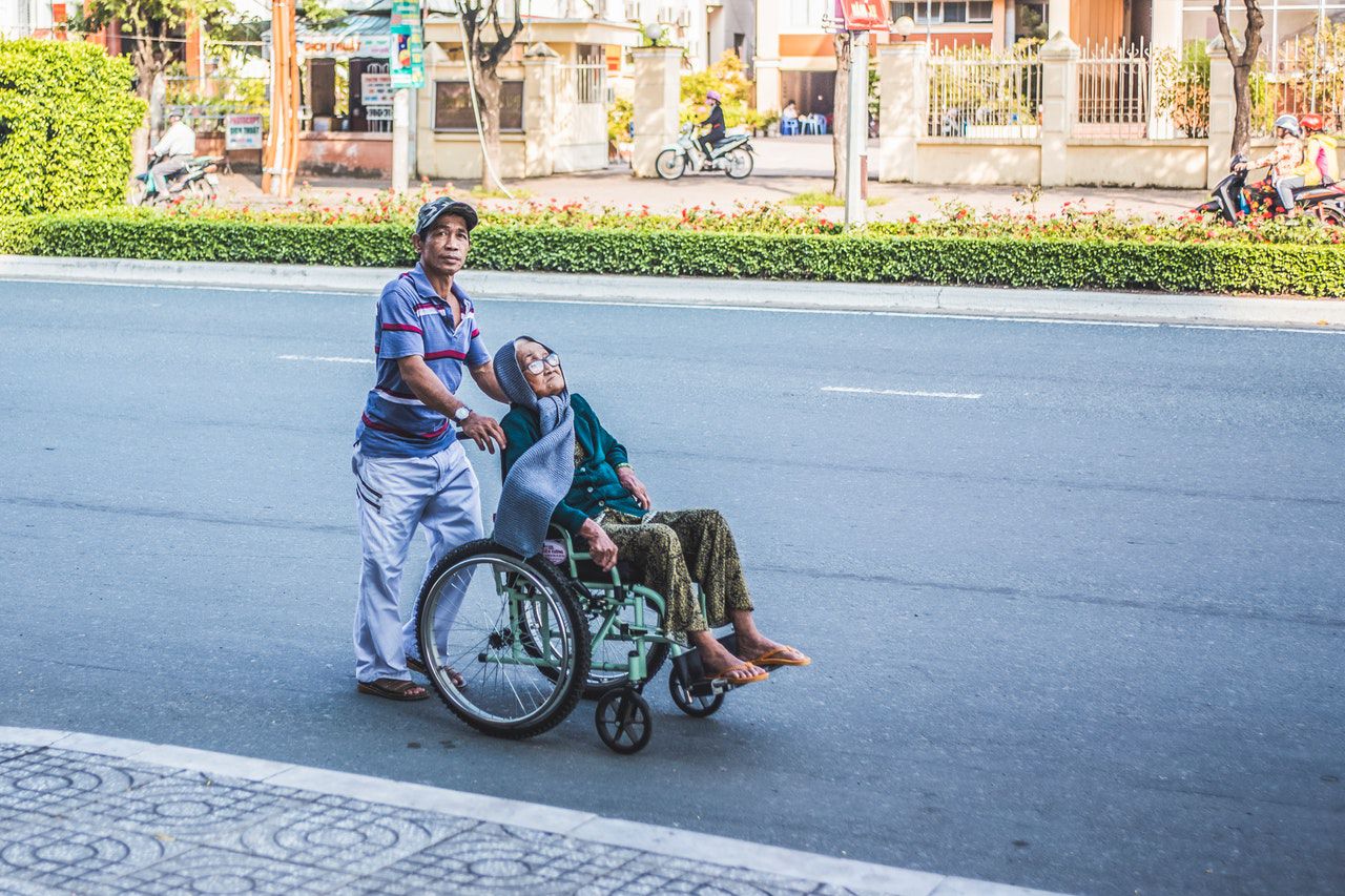 home empurrando a unha muller sentada nunha cadeira de rodas 3101214 - Sitio exipcio