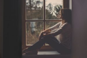 تجلس وحيدة وتنظر من شباك الغرفة وهي زعلانة